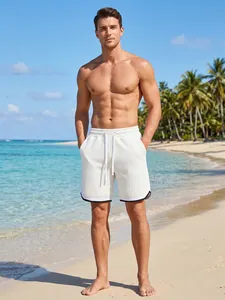 Premium men's white waffle knit athletic shorts with drawstring on a sunny beach