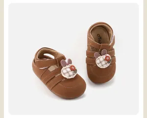 Detail van bruine babyschoentjes voor meisjes met schattige konijn- en bloemapplicatie