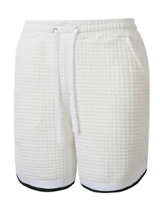 Close-up of white waffle texture shorts with drawstring and athletic trim detail