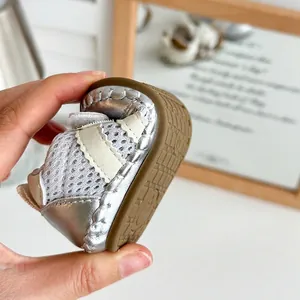Close-up of flexible soft sole on a silver baby mesh pre-walker shoe shown by hand