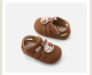 Gedetailleerde close-up van bruine babysandalen voor meisjes met schattige konijnenbloempatches