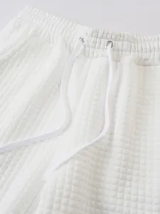 Detail view of white checkered waffle fabric sports shorts with drawstring elastic waist