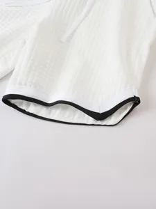 Close-up of waffle texture and contrast hem on men's white sports shorts