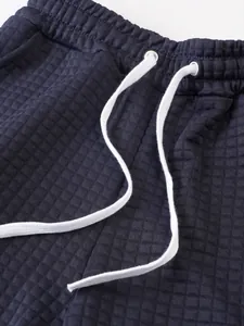 Close-up of navy waffle knit texture and white drawstring on men's sports shorts