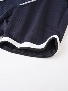 Macro detail of navy blue waffle texture fabric and striped hem on men's sport shorts