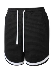 Detailed view of black men's athletic shorts featuring a waffle grid texture and white drawstring