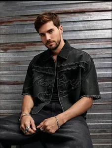 Détail d'une veste en jean noir pour homme avec franges effilochées et zip