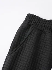 Detailed macro view of black waffle knit fabric and waistband on men's shorts
