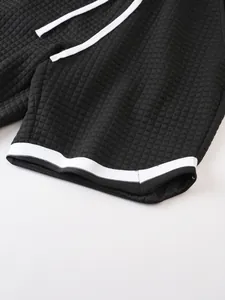Close-up view of black waffle texture on men's sports shorts with white trim