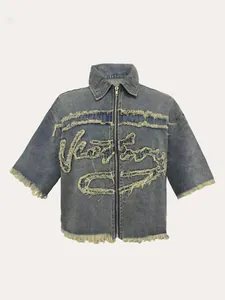 Gros plan sur une veste en jean bleue zippée avec bords effilochés et design graphique