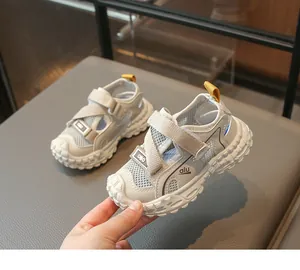 Detalle de sandalias de malla transpirable para niños con diseño de puntera cerrada y suela blanda.