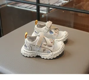 Detalle de la malla transpirable y el cierre de velcro en sandalias beige para niños