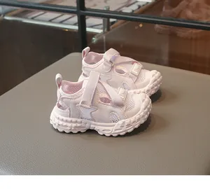 Primer plano de sandalias rosas transpirables para niños con suela blanda y cierre velcro.