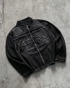 Vue détaillée d'une veste en jean noire avec broderies à franges effilochées et zip