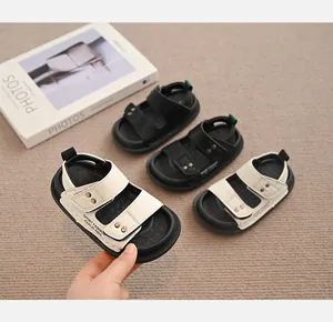 Nahaufnahme stilvoller weißer Kinder-Sandalen mit Doppelriemen und Nietenverzierung