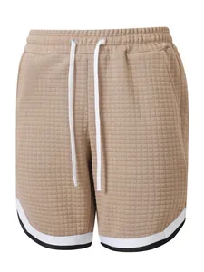 Detailed view of men's beige waffle textured sports shorts with white drawstring waist