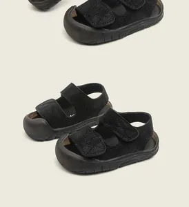 Close-up of black toddler sandals with closed-toe design and hook-and-loop straps