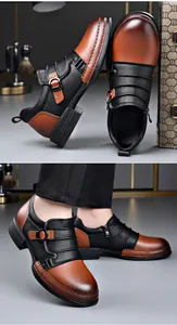 Close-up of men's two-tone leather Chelsea boots with side zipper and buckle detail