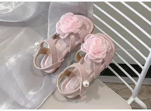Vista dettagliata di sandali rosa da principessa per bambina con fiori di stoffa e perle