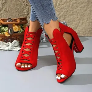 Detail of red suede peep-toe sandals with criss-cross laces and high block heel