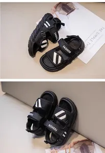 Close-up detail of black children's sandals featuring white diagonal stripes and Fashion strap
