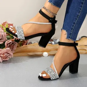 Detailed view of black chunky heel sandals with elegant and shiny silver glitter straps.