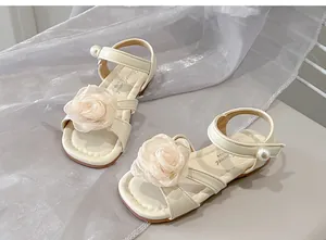 Dettaglio sandali color crema per bambina con fiore in rete e perla