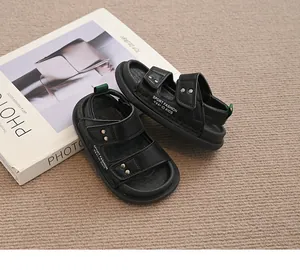 Detailansicht der schwarzen Kinder-Strandsandalen mit Doppelriemen und grünen Akzenten