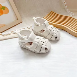 Nahaufnahme von weißen Leder-Baby-Lauflern-Sandalen mit Preen-Logo und Klettverschluss
