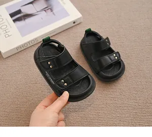 Nahaufnahme von schwarzen Kinder-Sandalen mit verstellbaren Riemen und Nieten