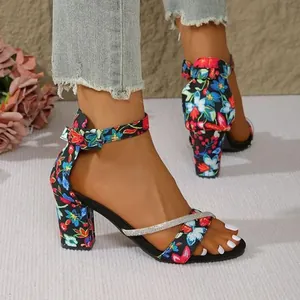 Close-up of floral print high heel sandals with rhinestone straps and ankle buckle.