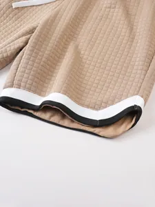 Close-up detail of men's summer sports shorts showing waffle grid texture and striped cuffs