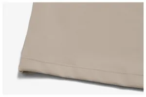 Detailed view of the double-stitched hem on a high-quality beige men's sports tank top