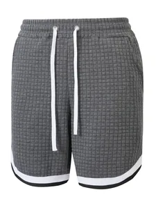 Close-up detail of gray waffle texture athletic shorts featuring contrast striped hem