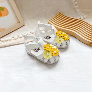 Nahaufnahme der weißen Preen Leder-Babysandalen mit gelben Blumenapplikationen.