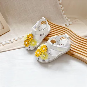 Detailansicht weißer Babysandalen mit gelben Blumenverzierungen und Klettverschlüssen