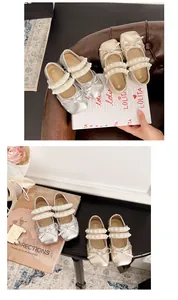 Détail de ballerines pour filles avec lanières de perles et nœuds élégants.