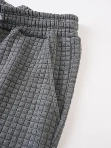Detail shot of men's gray sports shorts featuring a quilted waffle texture and side pocket