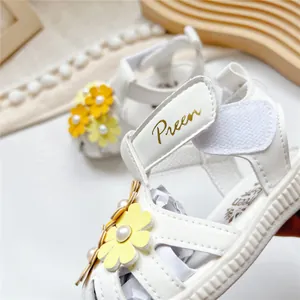 Nahaufnahme der Preen Baby-Ledersandalen aus weißem Leder mit gelben Blumenakzenten