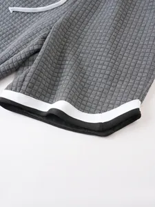 Macro close-up of men's waffle knit sports shorts featuring black and white hem detail