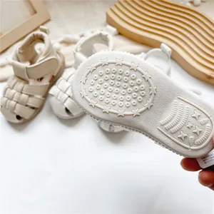 Detailansicht der rutschfesten Gummisohle mit Sternmuster an weißen Baby-Leder-Sandalen