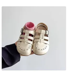 Close-up of vintage hollow-out cream leather sandals for children with closed toe