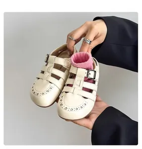 Close-up of vintage cream children's Roman sandals with star-shaped perforated details.