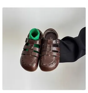 Macro view of retro brown hollow leather sandals for children with decorative star perforations