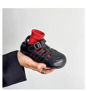 Close-up detail of black retro hollowed Roman leather sandals for boys and girls