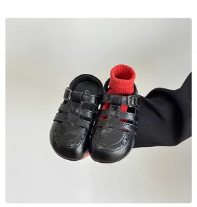 Detailed view of children's vintage black hollow leather sandals with elegant buckle strap