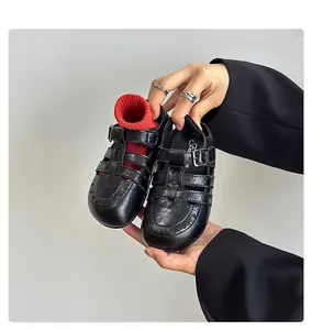 Close-up of children's retro black hollowed-out Roman sandals with soft leather soles