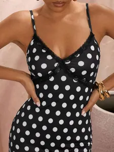 Close-up of classic black polka dot slip dress with elegant lace trim at V-neck design
