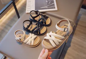 Vue détaillée de sandales romaines élégantes pour filles en blanc cassé et noir.