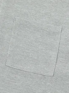 Detailed macro view of the waffle-knit fabric and chest pocket on a gray retro T-shirt
